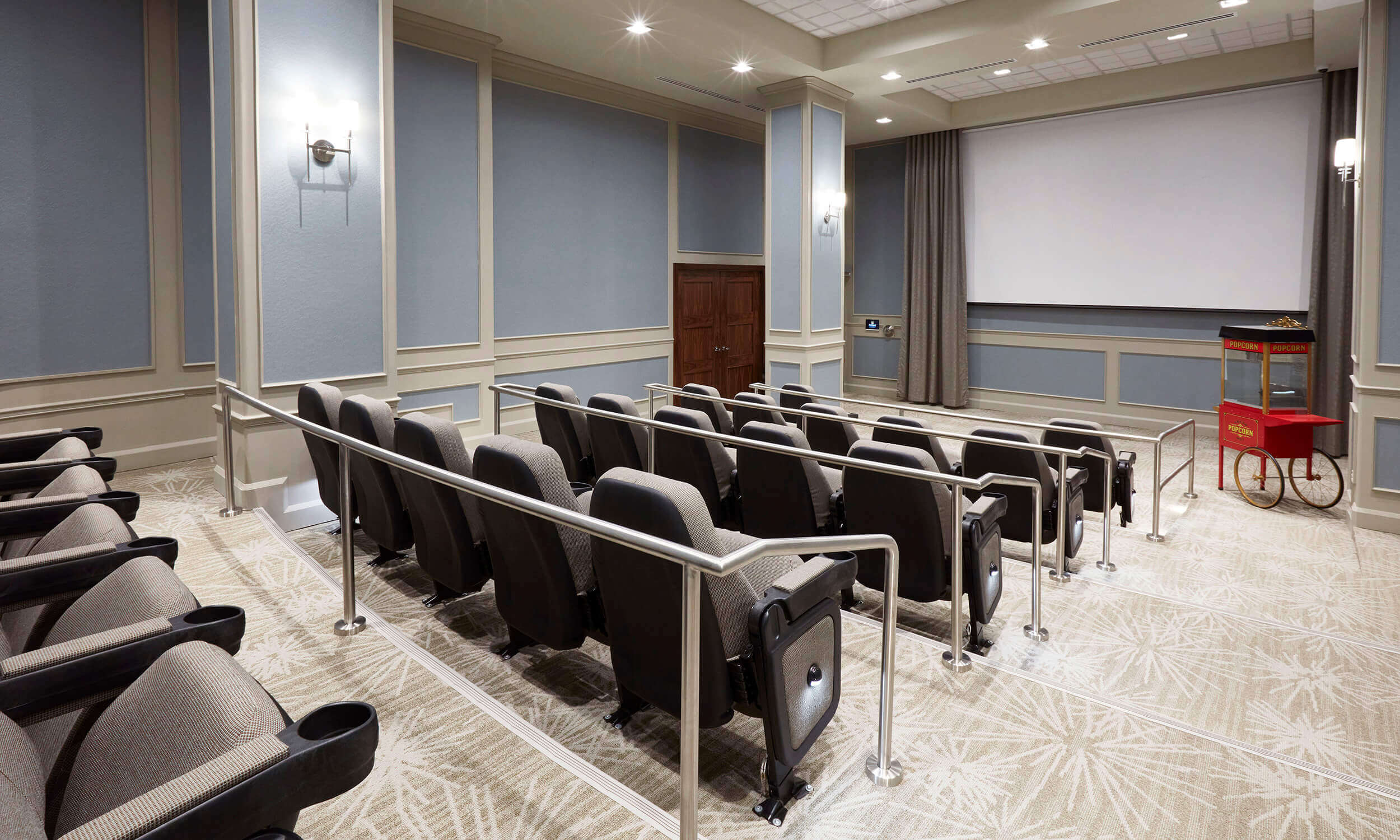 Entertainment room of retirement home with large movie screen  and rows of seating