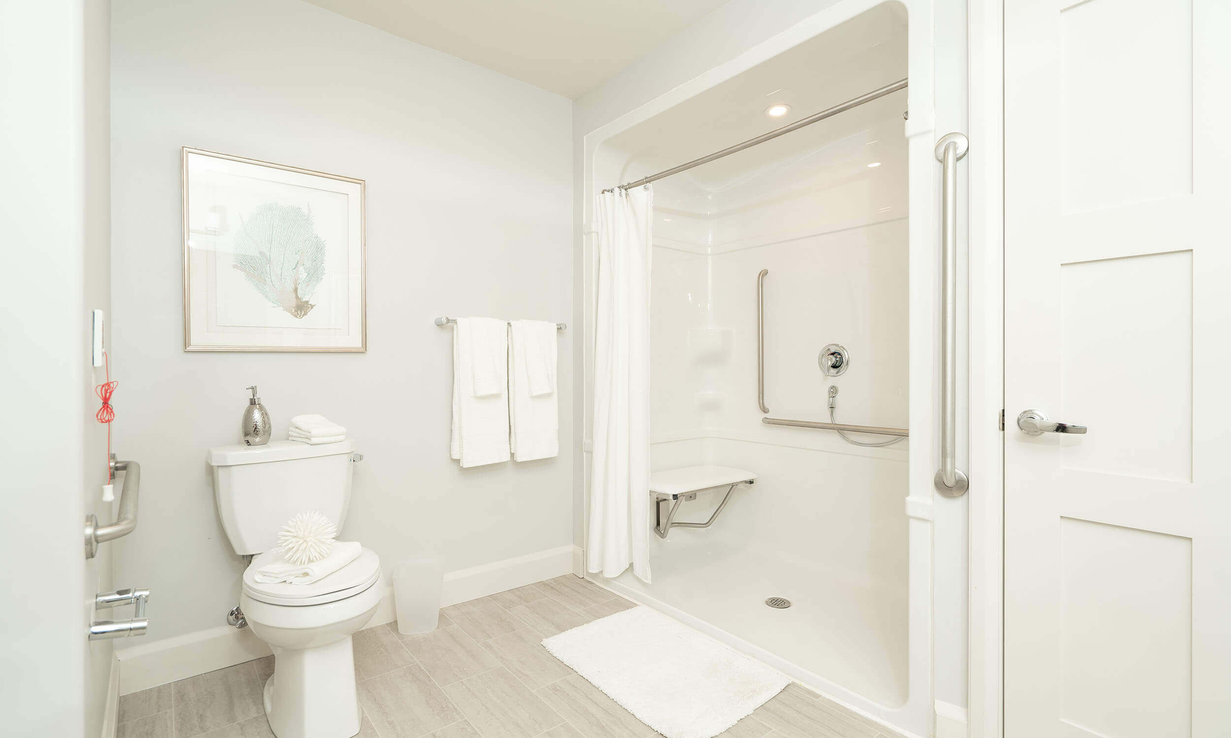 White bathroom in Parkland suite with white and wood vanity, toilet, and spacious shower