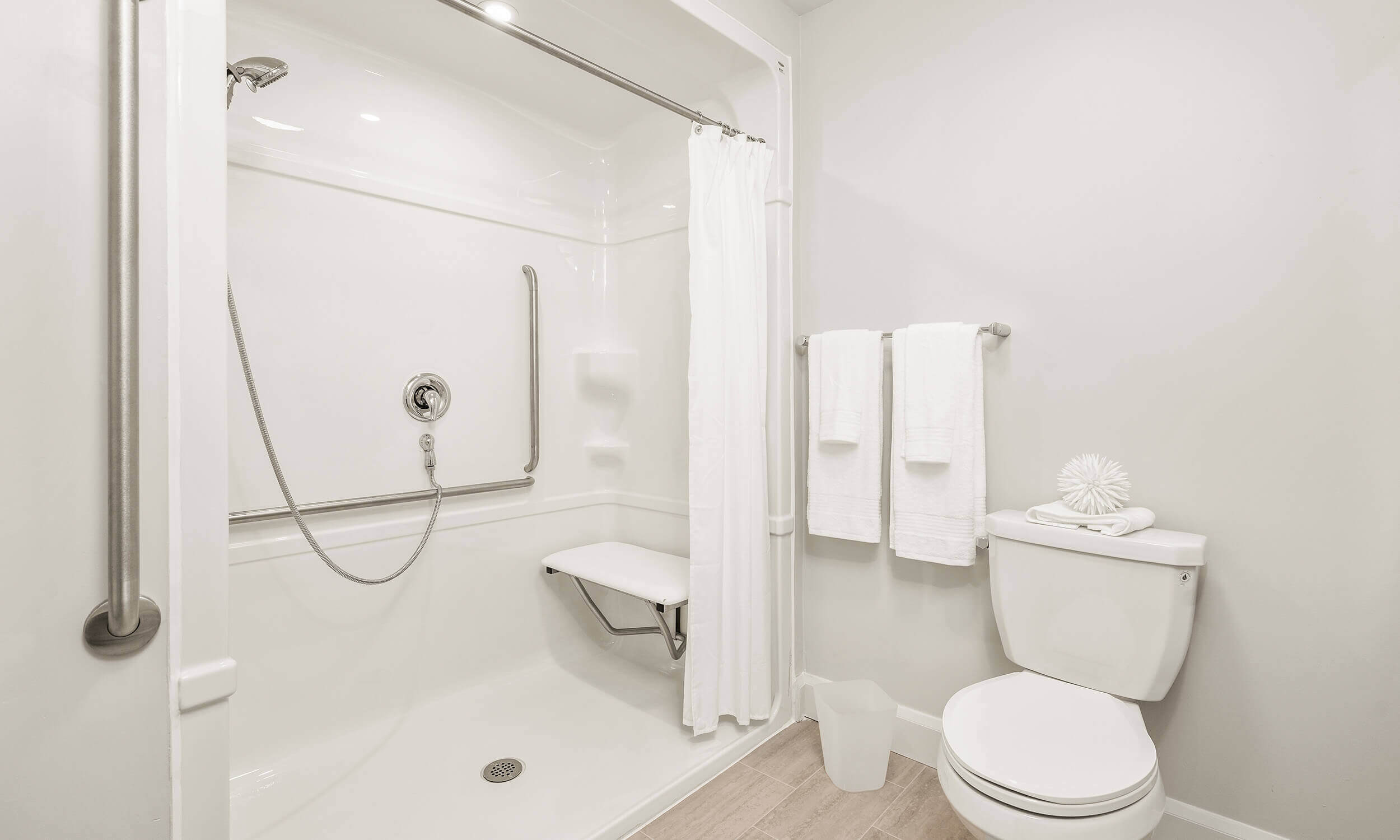Modern white washroom with toilet and spacious shower