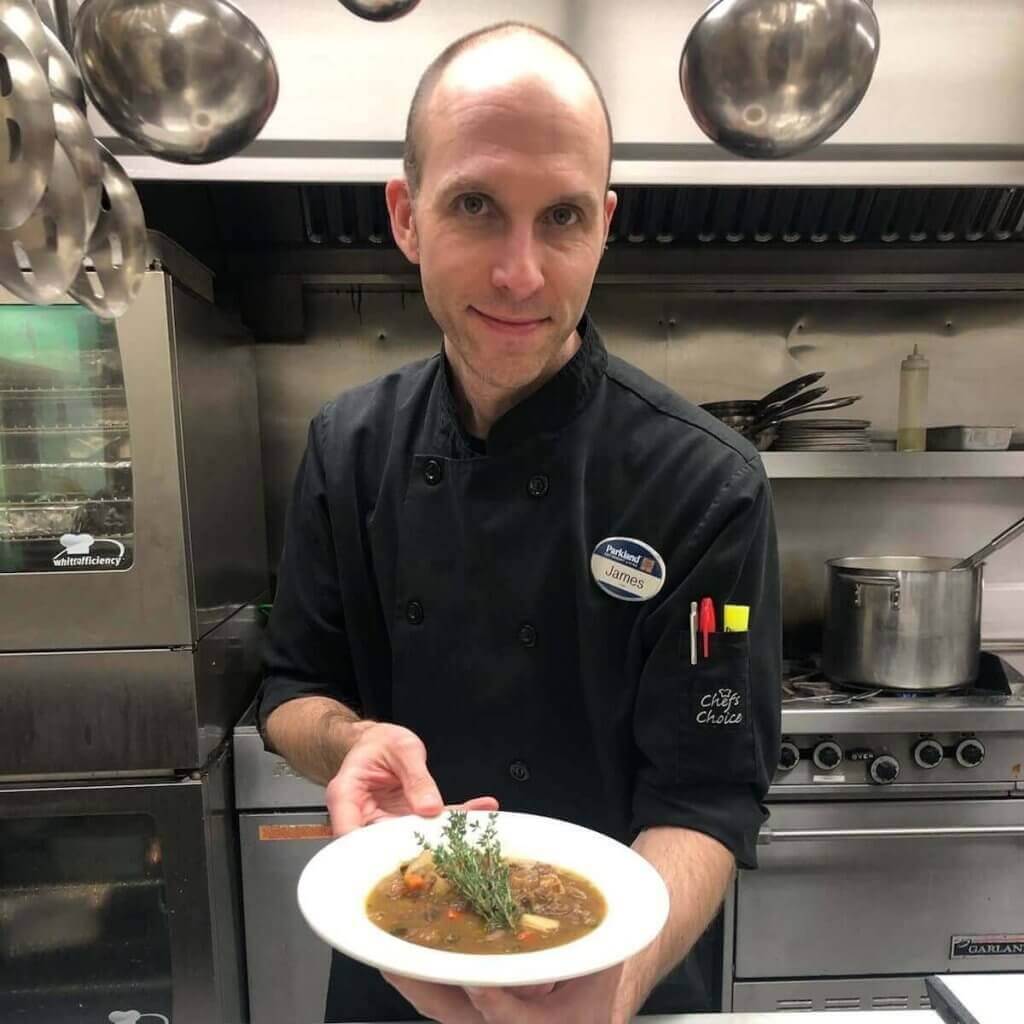Parkland chef presenting stew dish in kitchen