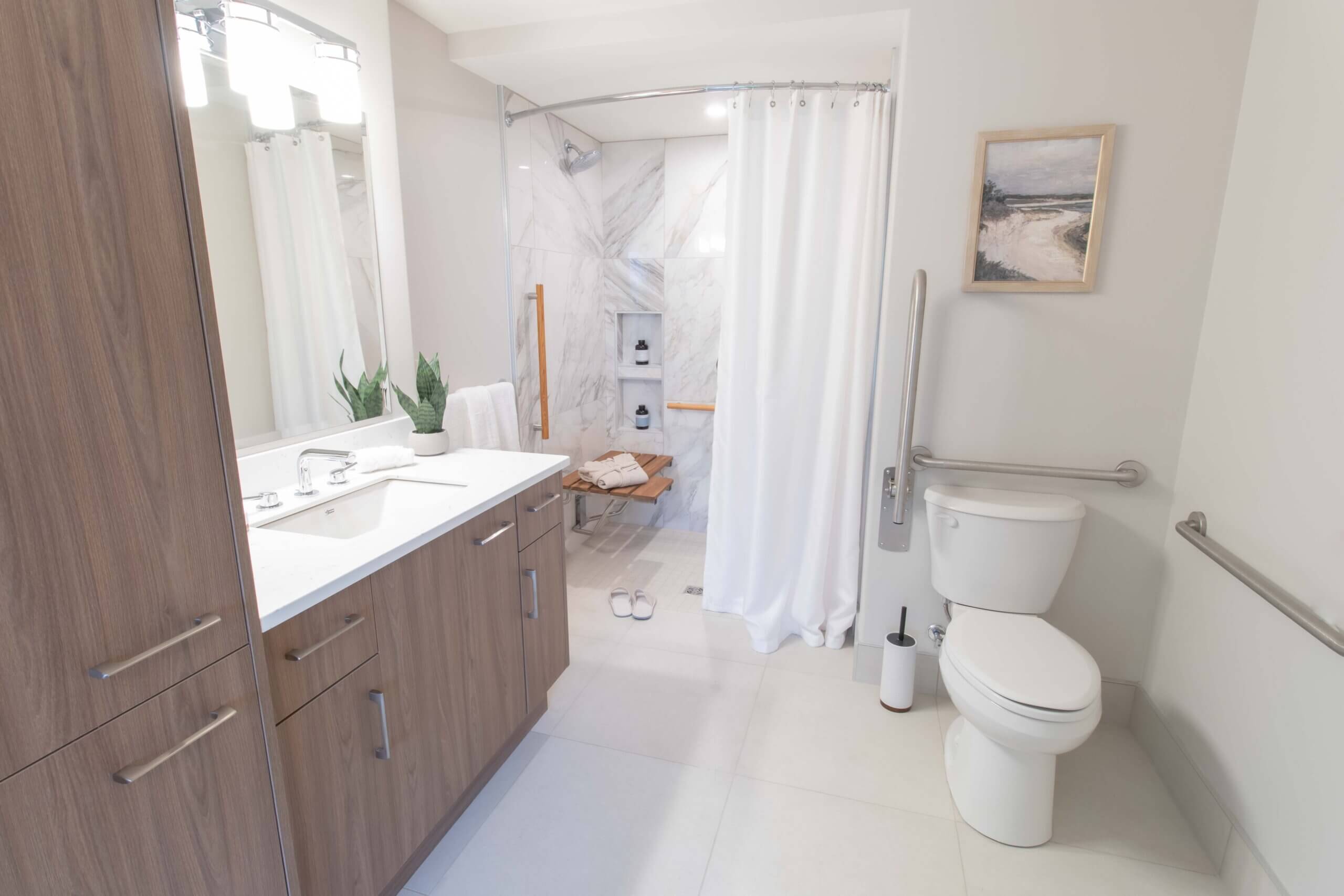 A modern bathroom with a toilet, shower, sink and mirror.