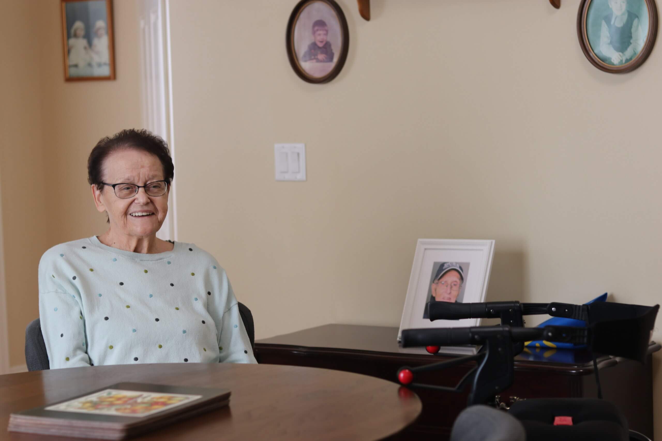 Brenda, a Parkland resident sits at a round table with a photo of her late husband, Clyde in the background.