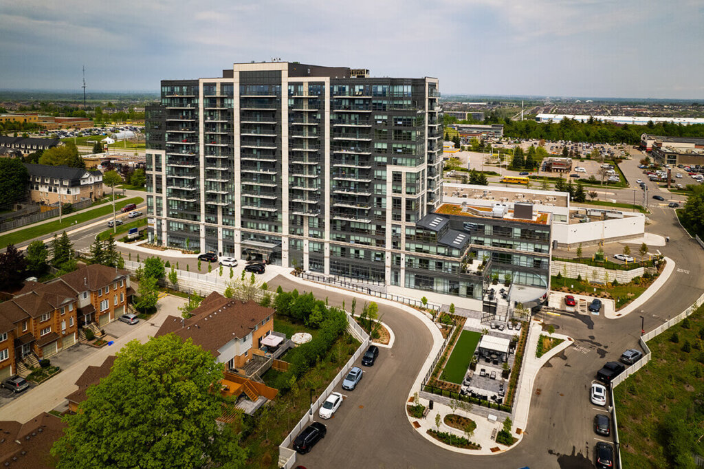Modern multi-story retirement home with large windows surrounded by green space