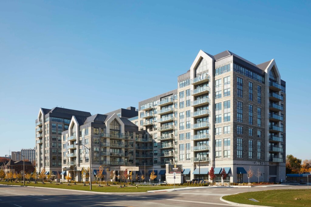 Modern multi-story retirement home with large windows surrounded by green space